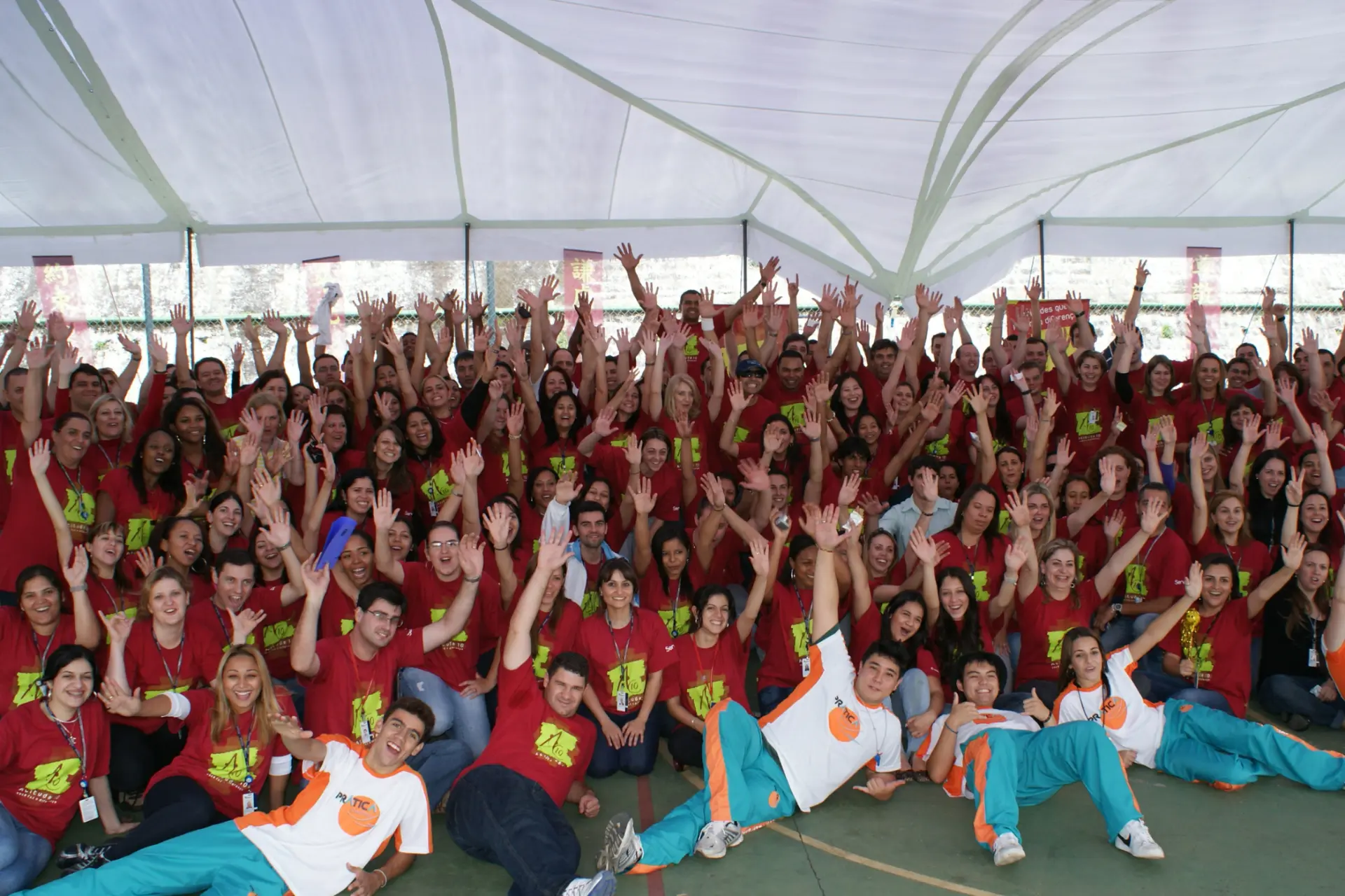 Grande grupo de colaboradores com a equipe de recreação em foto final de evento de SIPAT