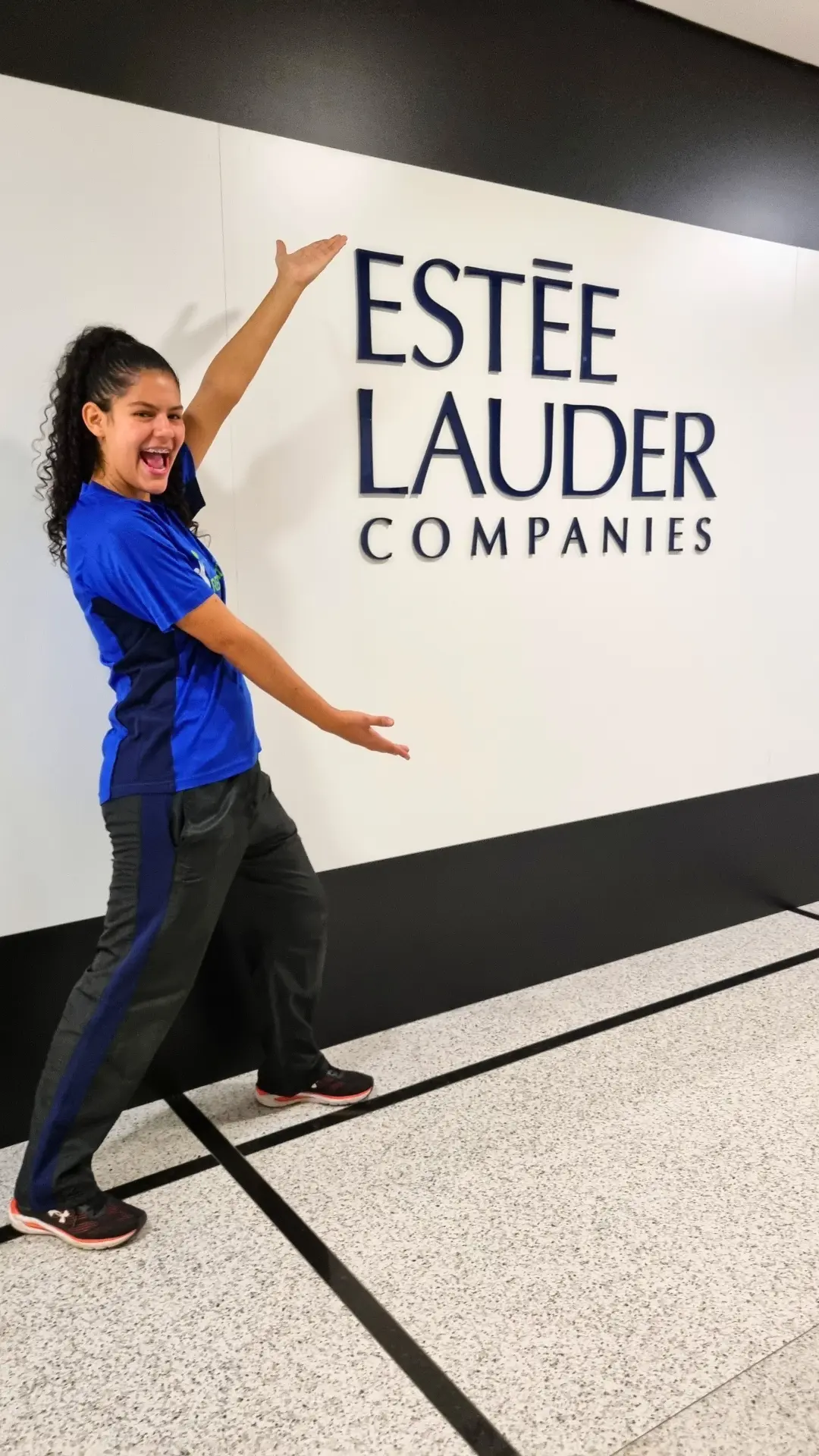 Recreadora da Prática Recreativa em frente ao letreiro da Estée Lauder Companies