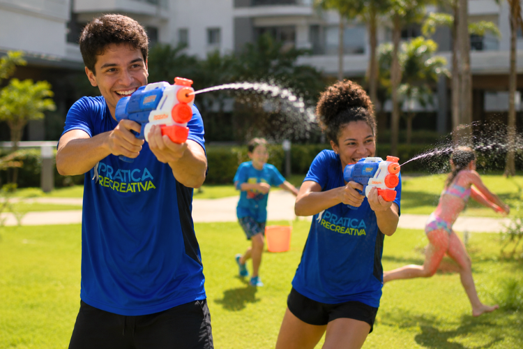 Recreadores em brincadeira com água em dia de verão