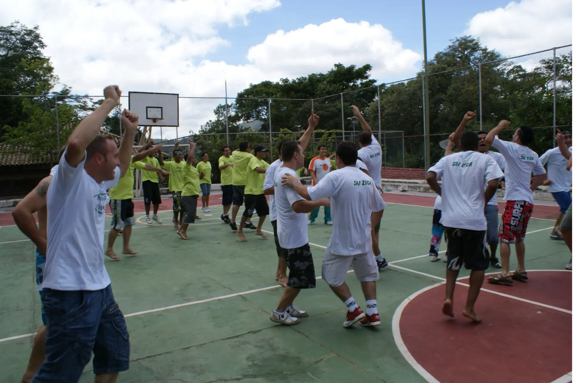 Colaboradores de equipes coloridas em atividade recreativa na quadra durante evento corporativo