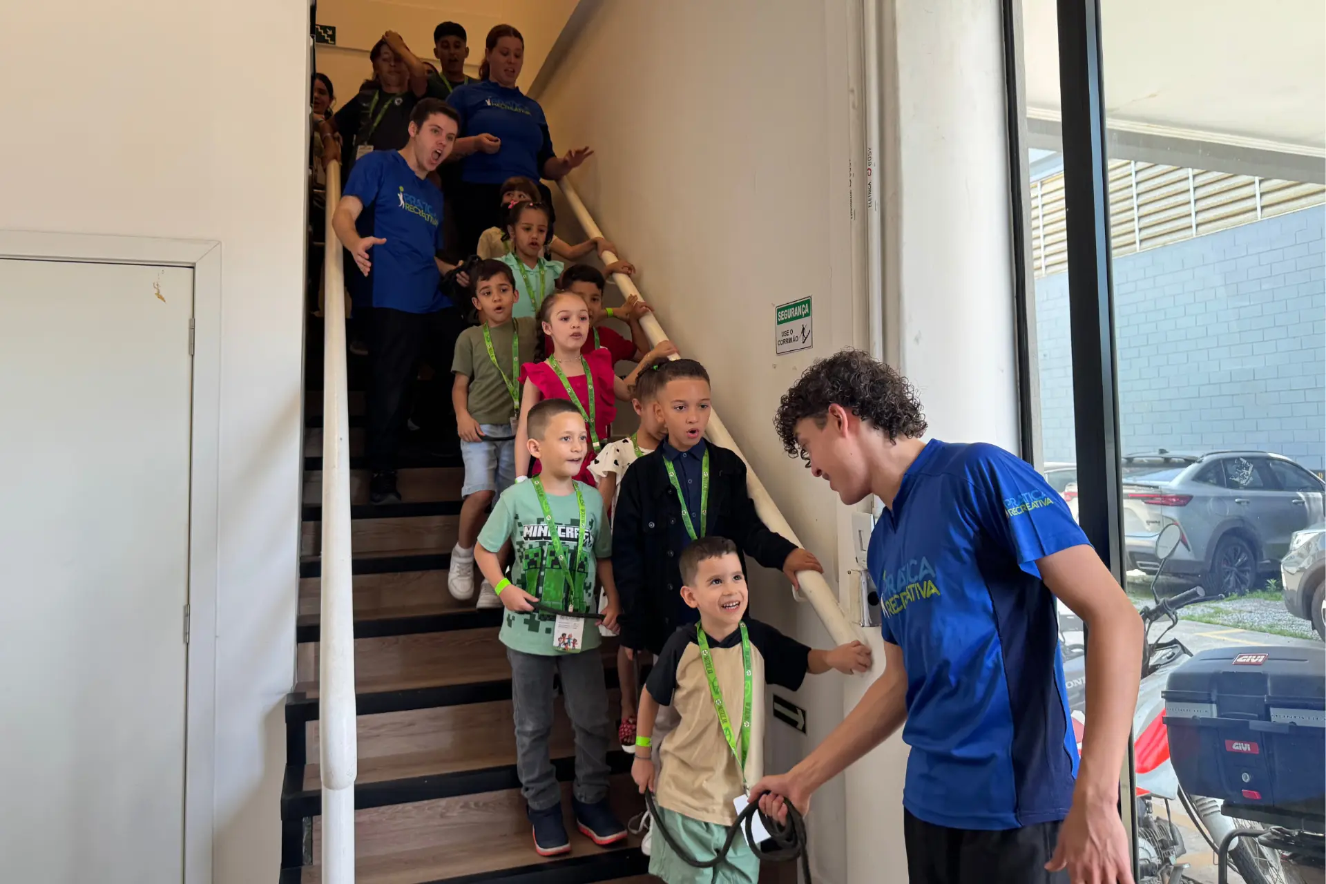 Crianças chegando ao evento corporativo acompanhadas pela equipe de recreação