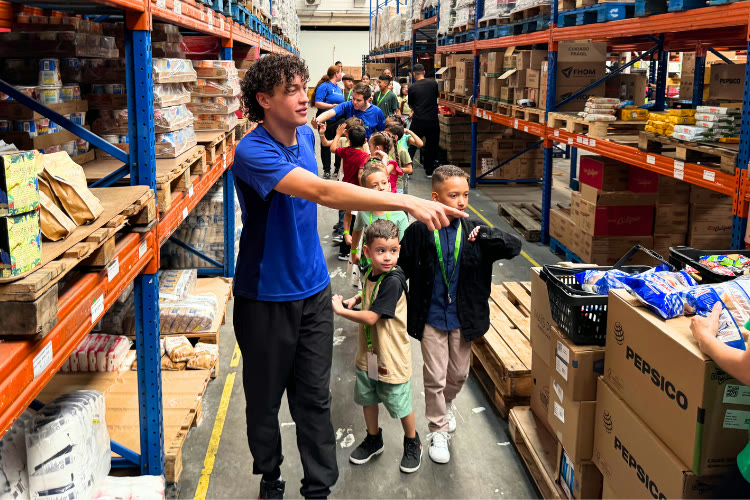 Recreador conduzindo grupo de crianças em visita durante Kids Day
