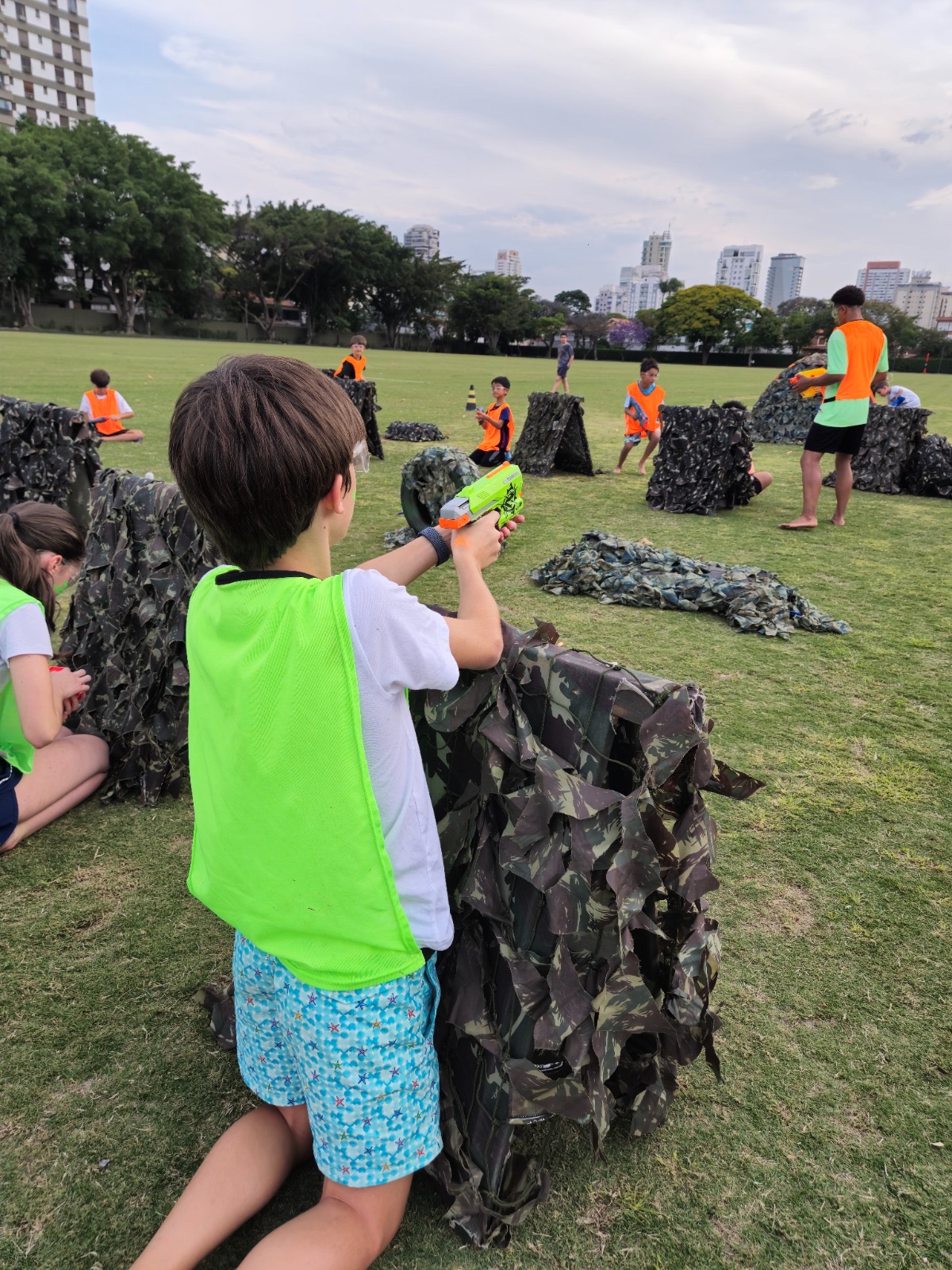 Arena Nerf montada em área externa ampla com obstáculos de camuflagem