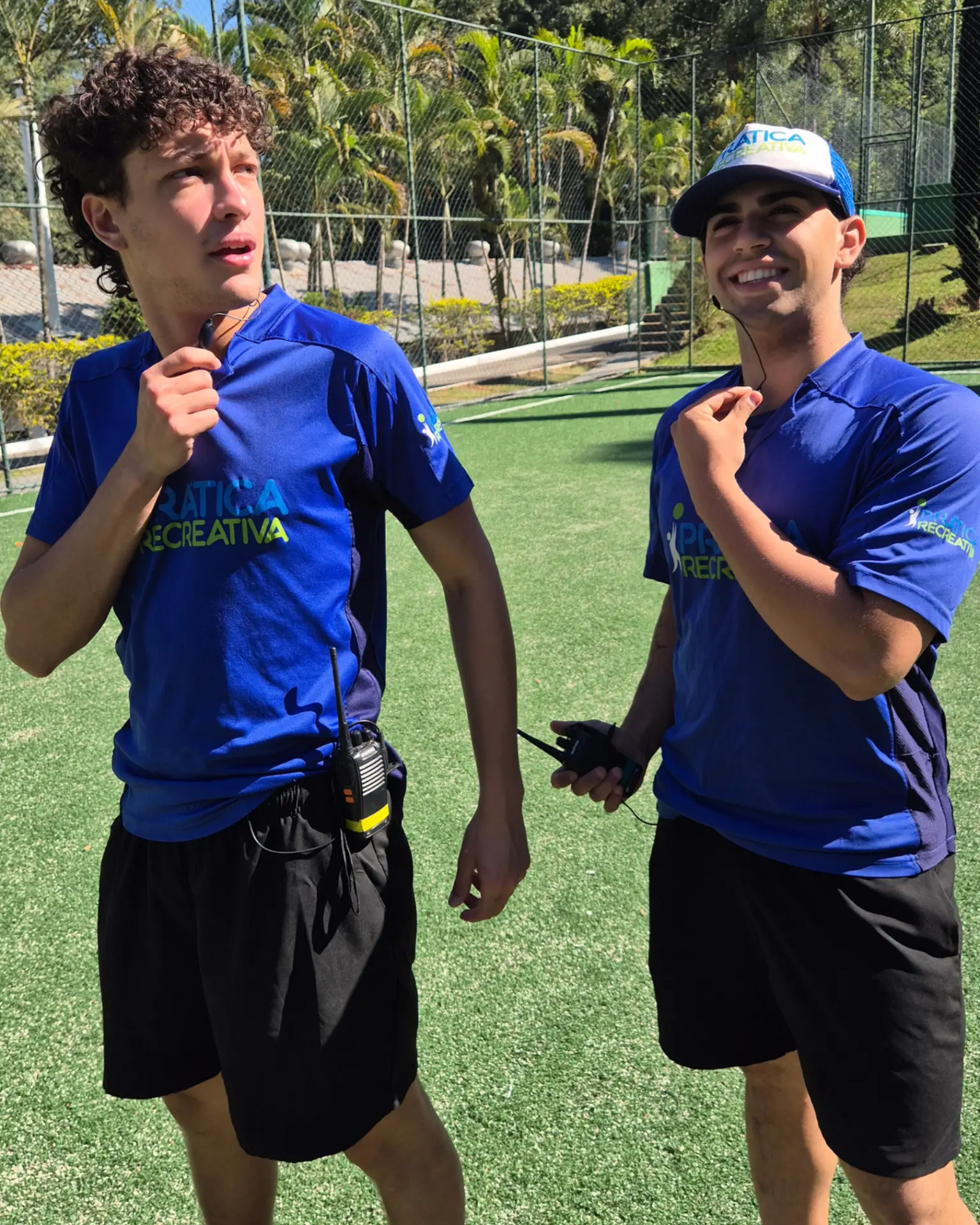 Dupla de recreadores da Prática Recreativa com rádio comunicador em dia de festa